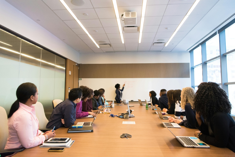 A group of people sitting at tables in front of laptops.