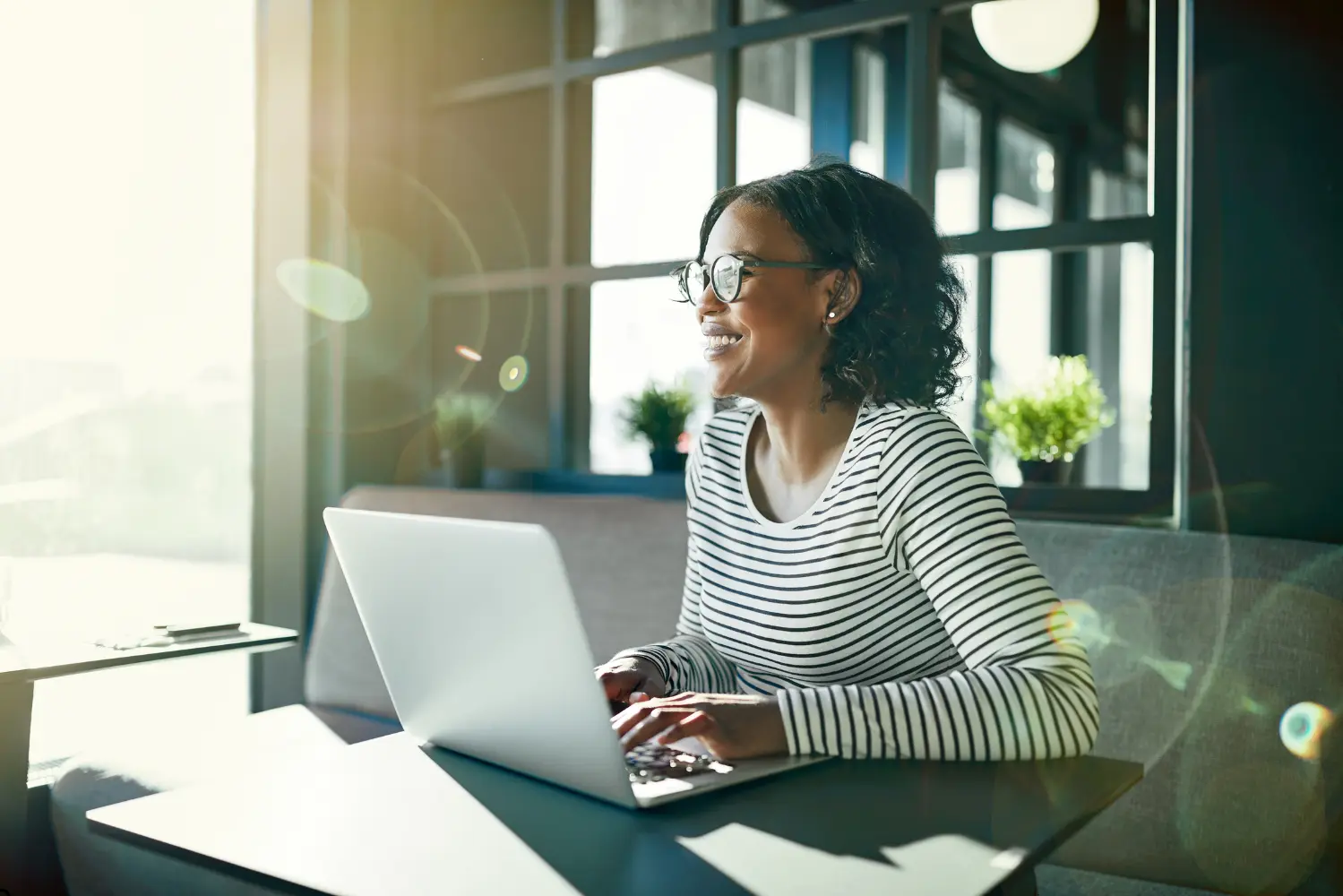 A woman sitting at a table with her laptop.