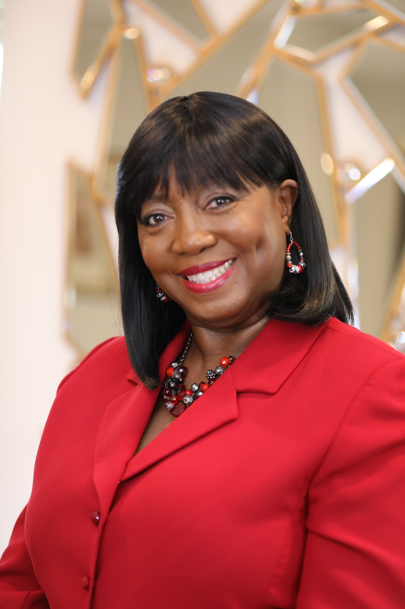 A woman in red jacket smiling for the camera.